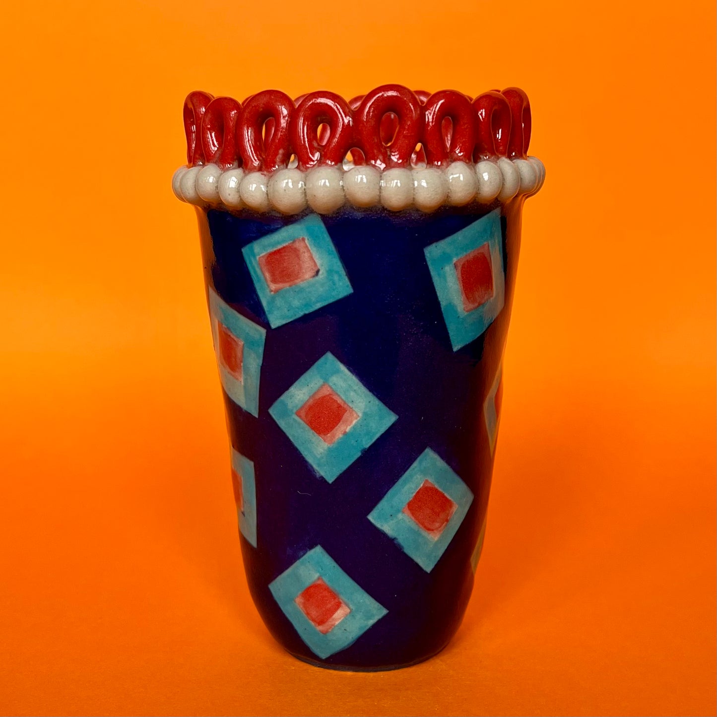 Red Droplet Crown with Turquoise and Red Rectangles on Blue