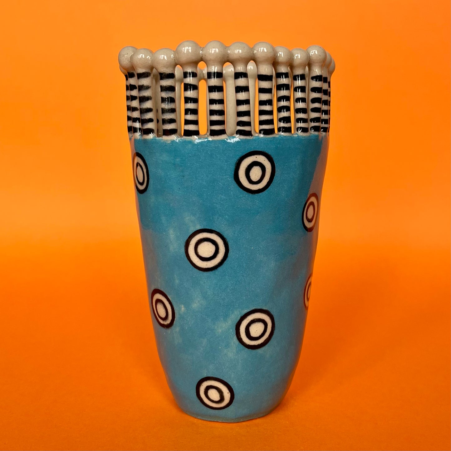 Turquoise Man with White and Black Circles and Stripy Lollipop Crown