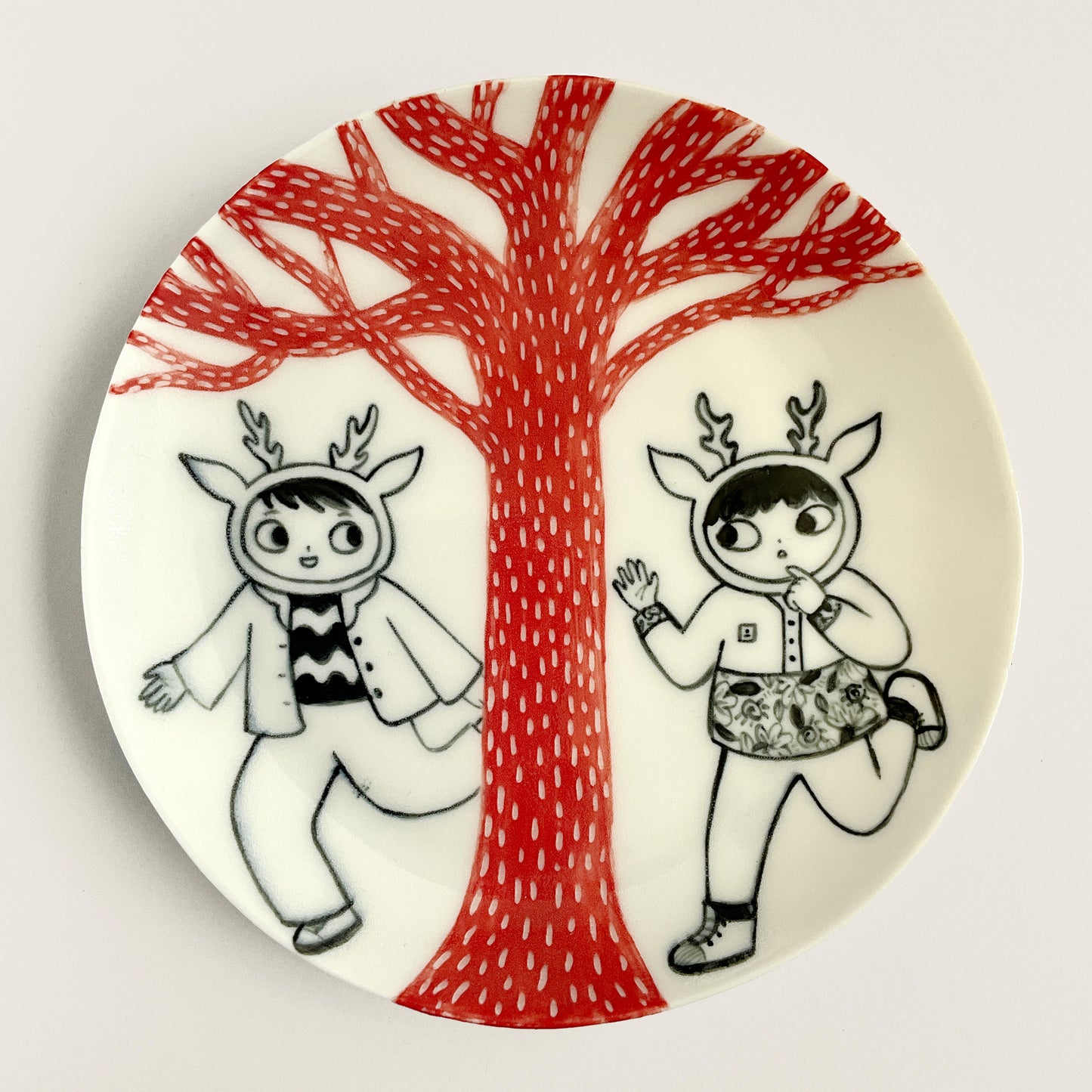 Deers run past a Red Tree plate