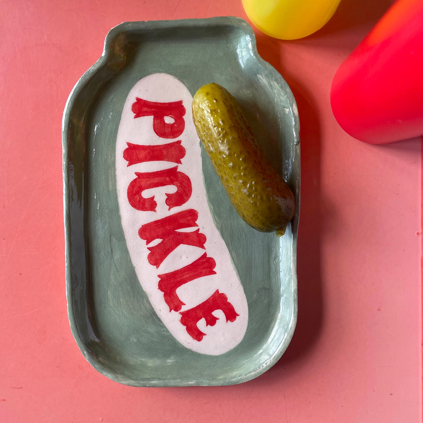Pickle Dish with a pickle on a red background